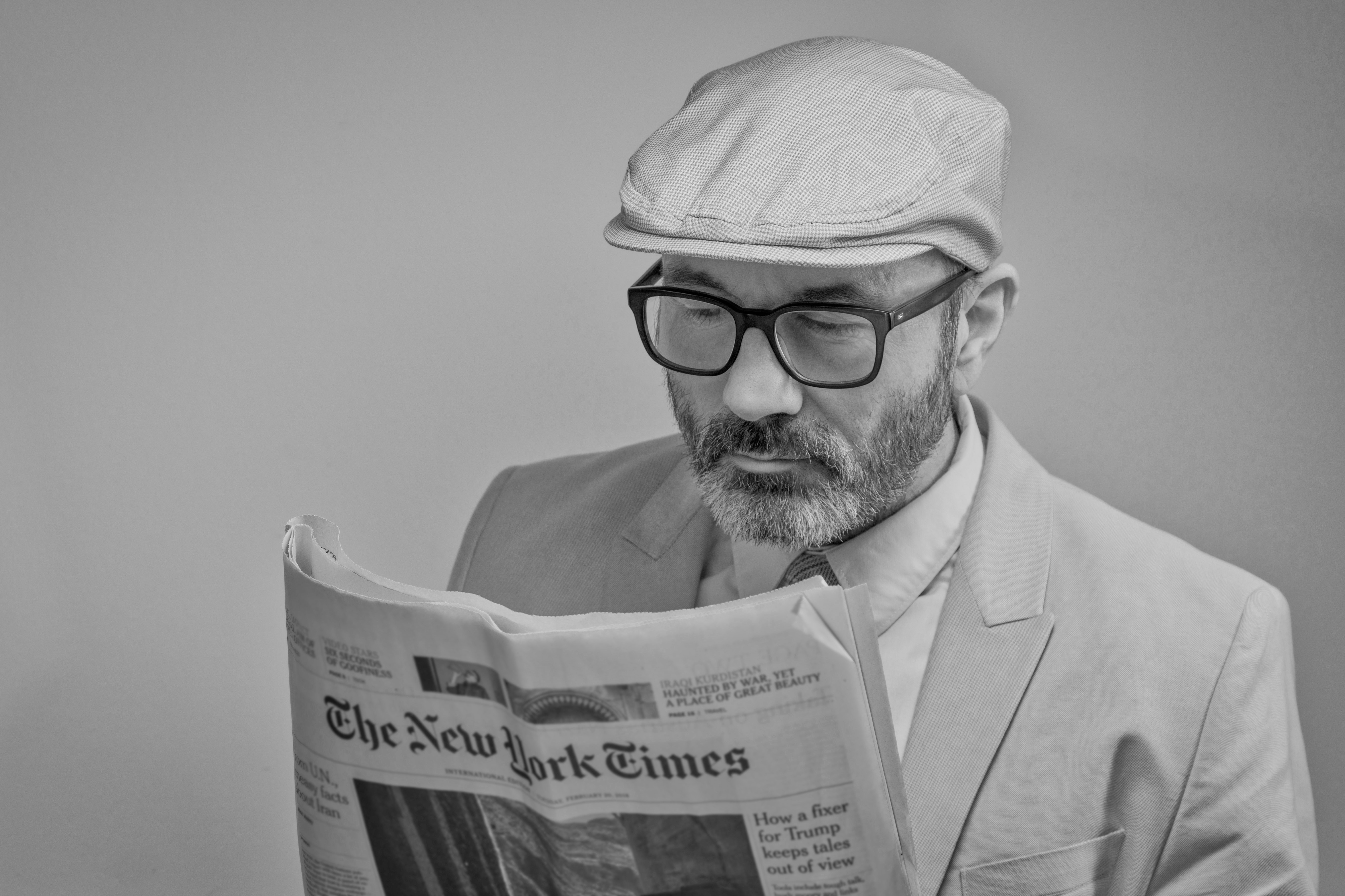 Man with glasses reading a newspaper