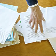 Hand pointing out document on a table.