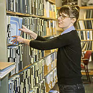 Woman searching for books on a library bookshelf