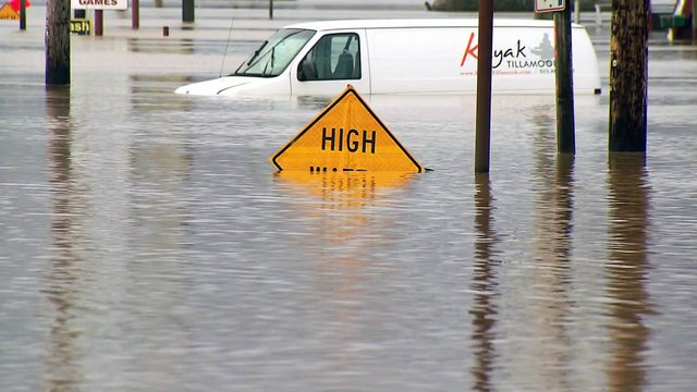 Flood water surrounding a high water sign