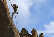 Rock climber ascending a steep cliff