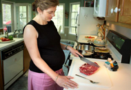woman cutting meat on cutting board