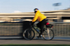 Man riding a bike, with blur indicating movement