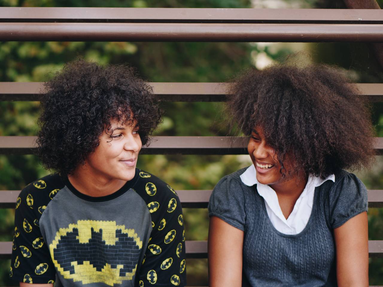 two Black teens sitting outside