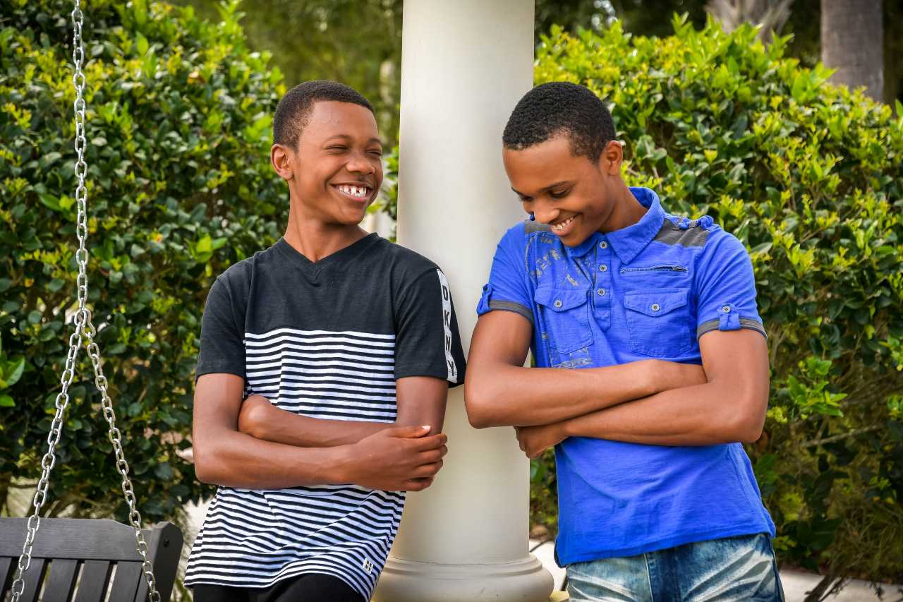 two Black teenage boys standing outside