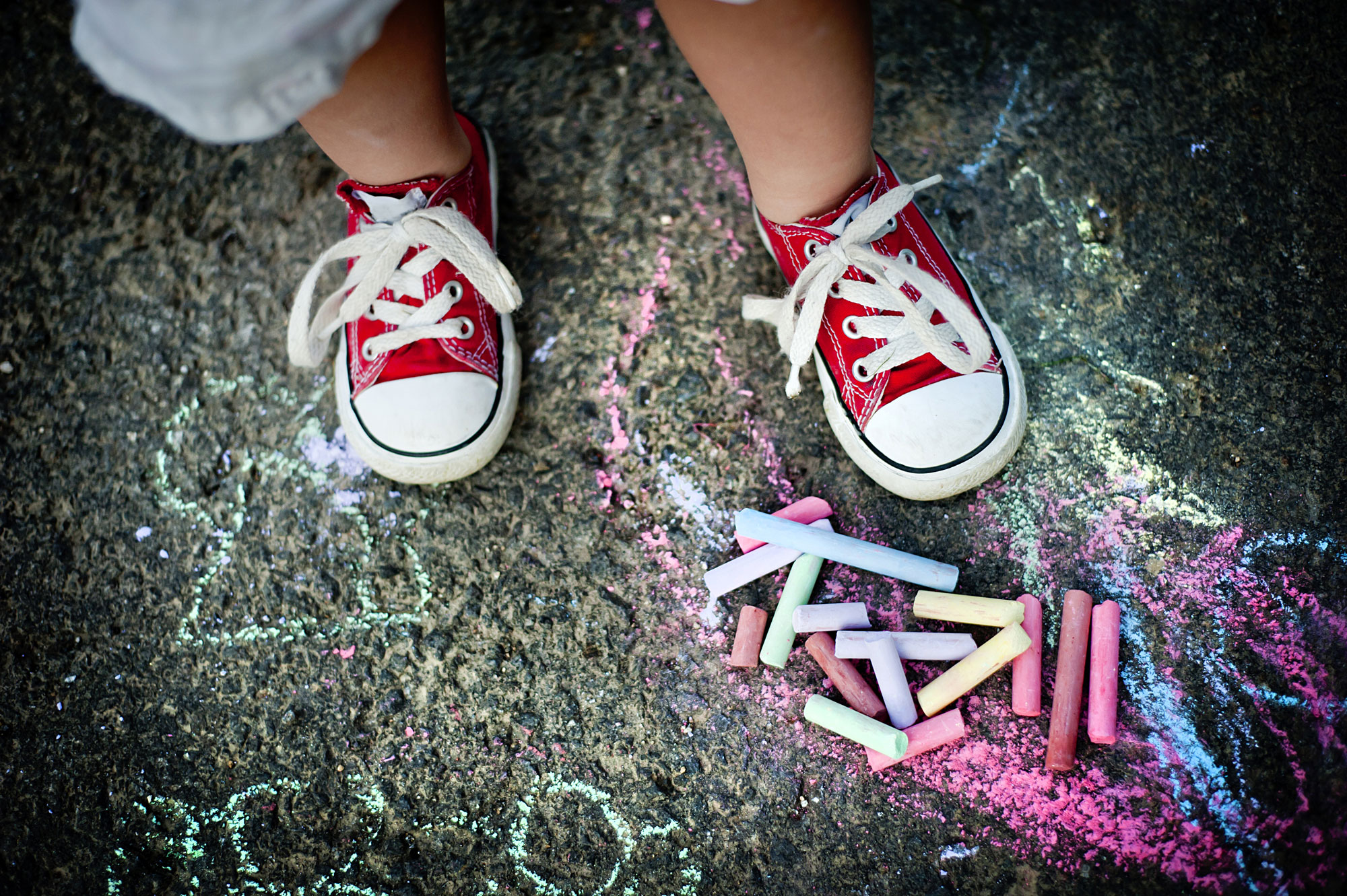 child shoes next to chalk drawing