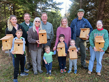 Group of people hold bird boxes