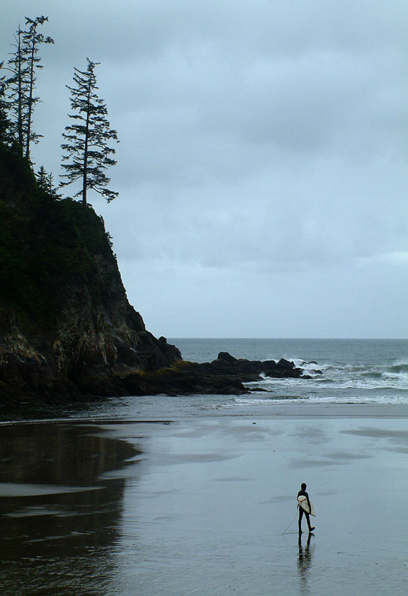 A Lone surfer walks toward the surf