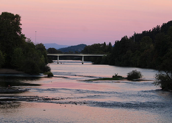 A pink sunset stretches over the Willamette River