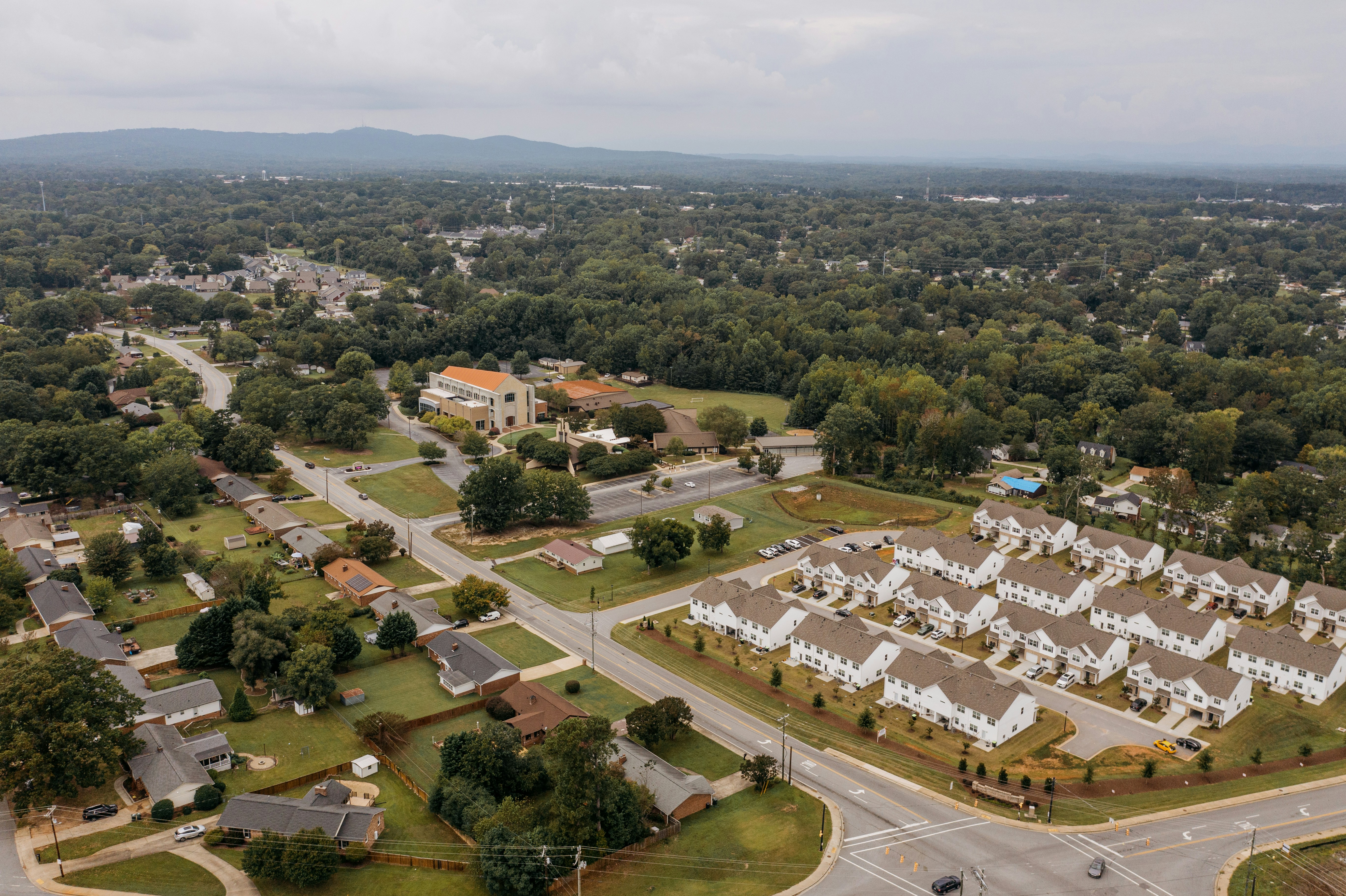 Aerial view of a suburban town with houses spread apart in one area and houses clustered together in another.