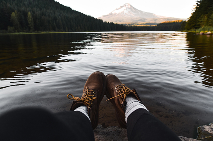 Boots in front of a lake with a mountain in the background