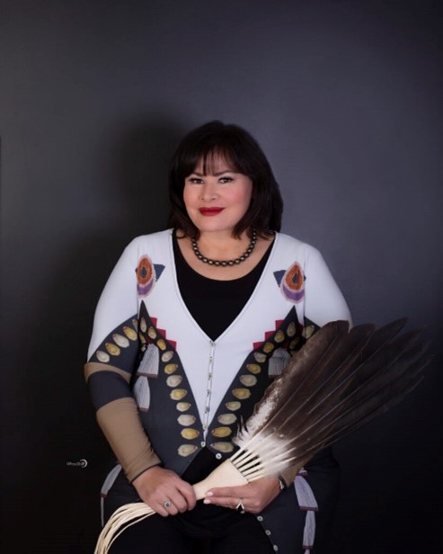 Angeline Boulley, author, in native outfit with feathers