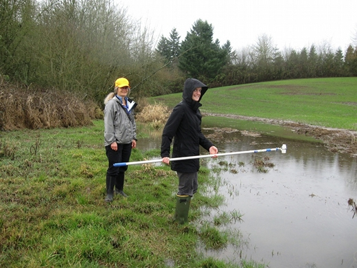 Two employees collecting a water sample.