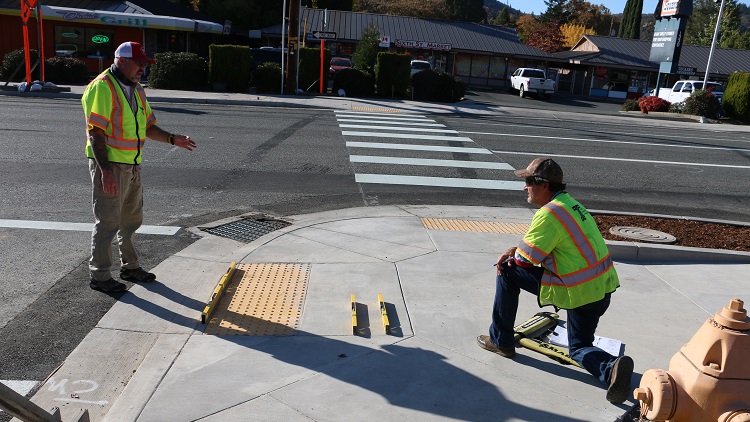 Two engineers inspecting ada curb ramp with three levels.