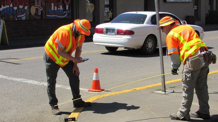 Two crew staff inspecting and documenting ADA curb ramps.