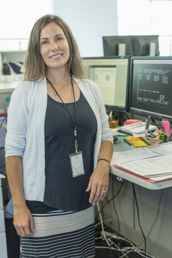 Employee standing in front of a computer desk