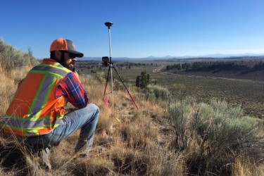 Surveyor measuring land in a rural setting