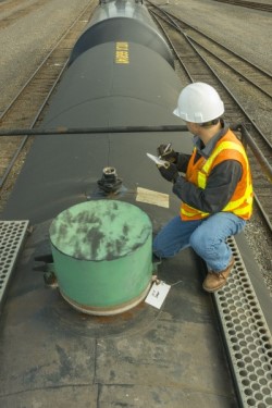 Employee inspecting the top of a train car