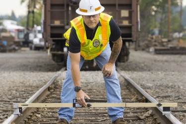 Employee measuring the width of railroad ties