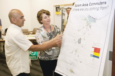 Two employees looking at a Salem area commuter map