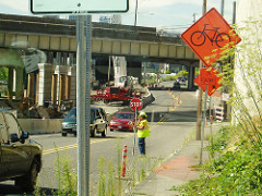 A flagger helps direct traffic through a work zone in north Portland.
