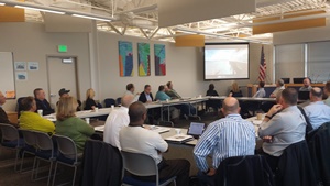 Photo of participants sitting around a table at a Motor Carrier Transportation Advisory Committee meeting.