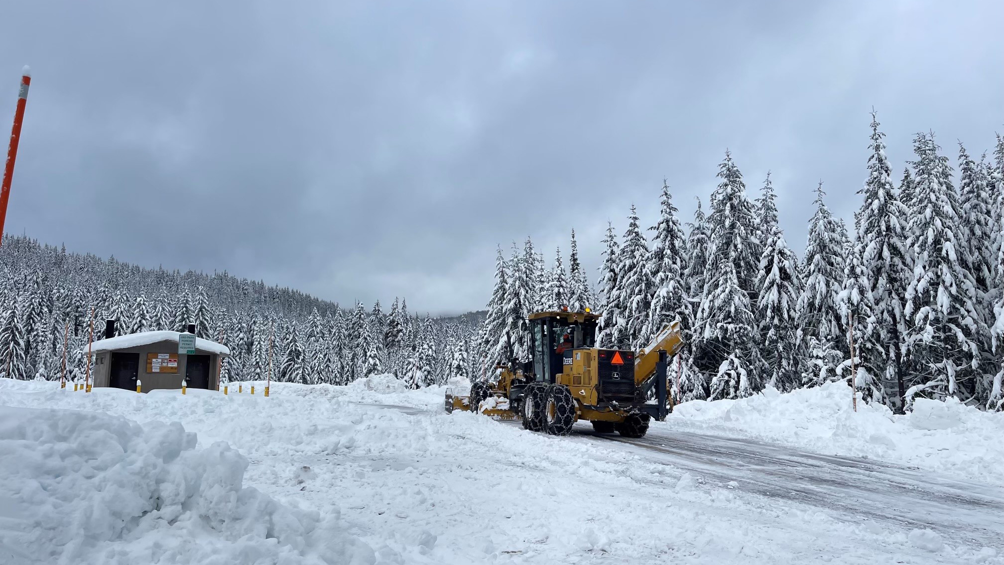 Crew member plows snow from a Sno-Park located on Willamette Pass. March 2023.