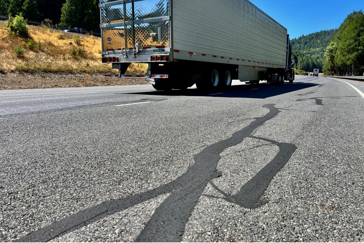 Closer view of the road surface shows wearing pavement.