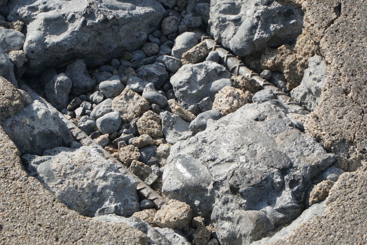 The pavement damage is especially significant in some areas where the concrete is breaking down and rebar is visible. 