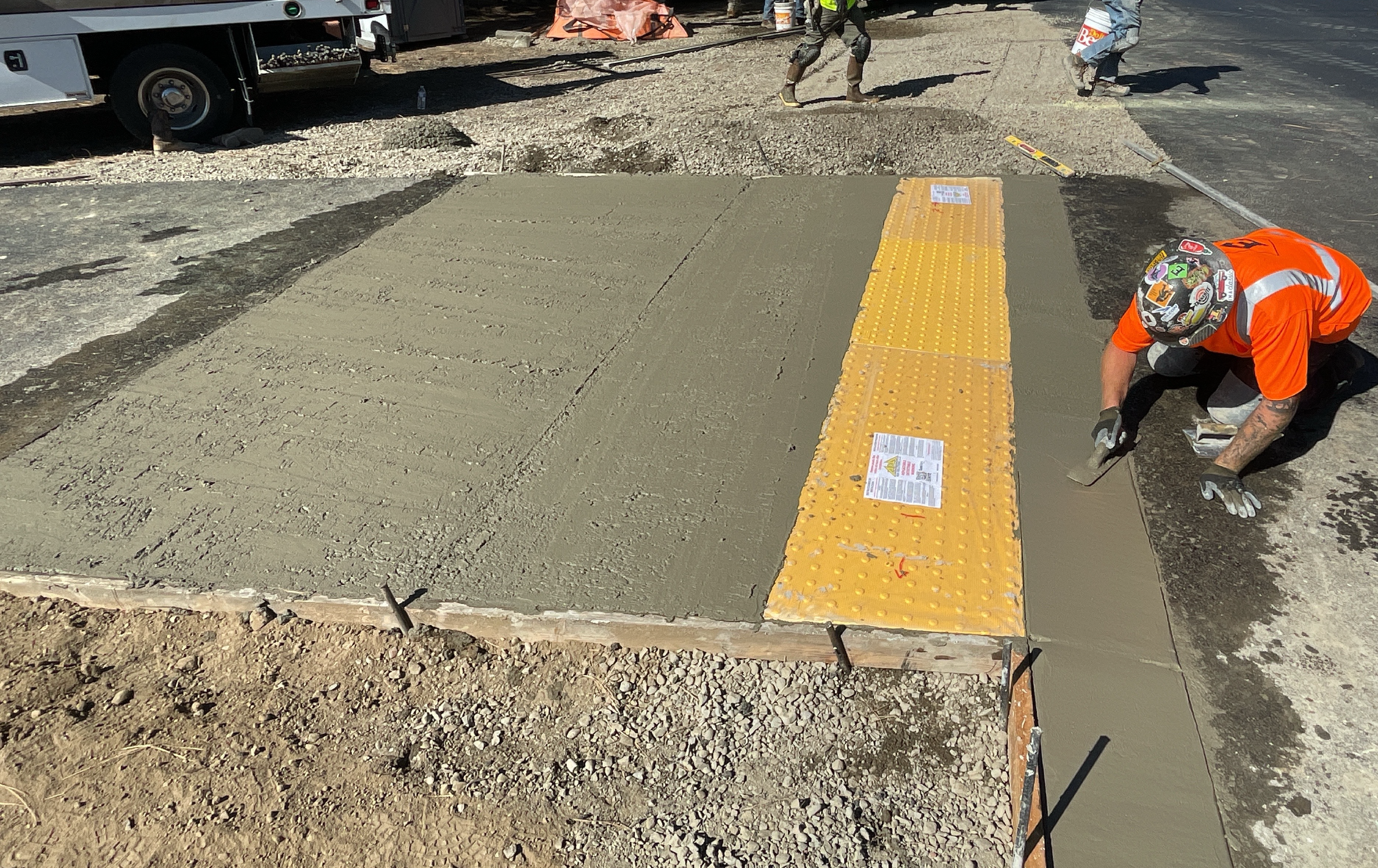 picture of worker leveling cement on an ADA ramp under construction