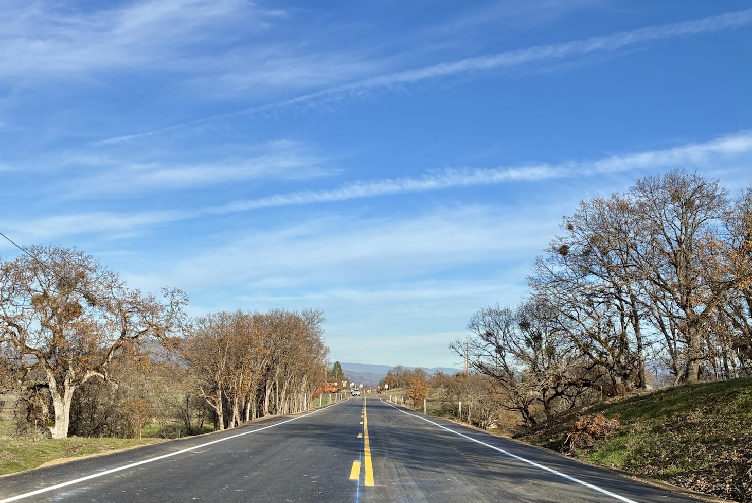 Crews smooth gravel on the roadway to prepare for paving.