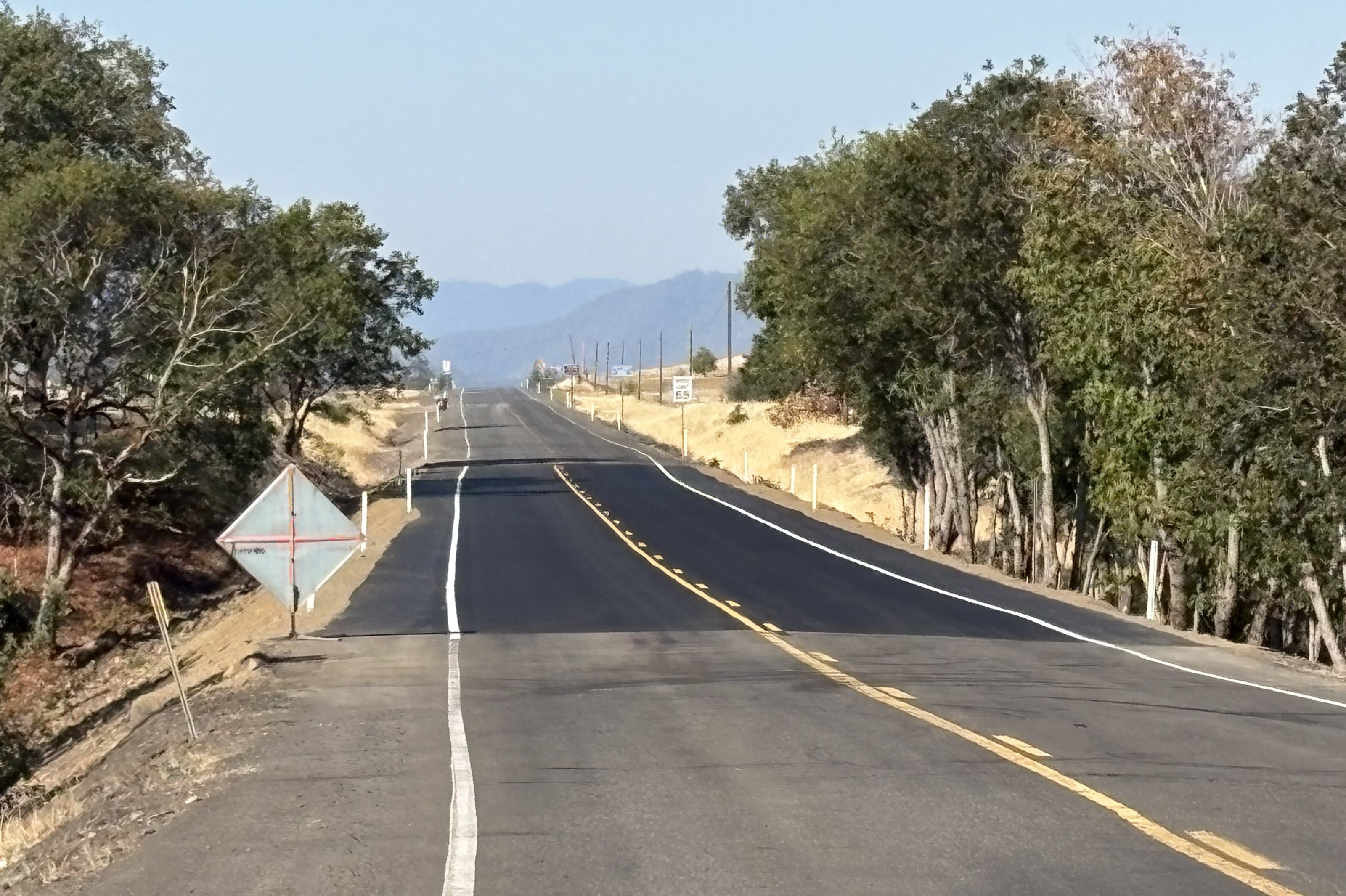 Crews smooth gravel on the roadway to prepare for paving.