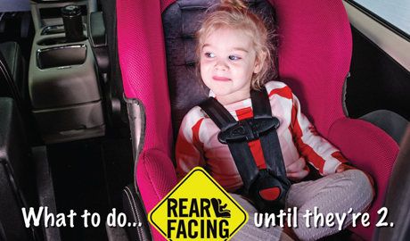 A young child sitting in a rear facing child seat