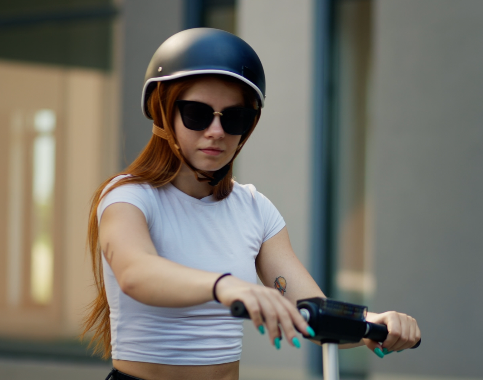 Woman wearing helmet on an e-scooter