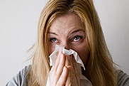 Women blowing her nose because of allergies.