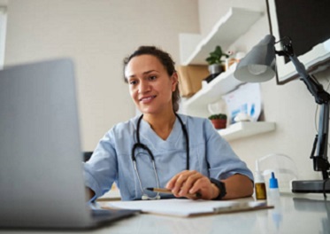 Doctor clicking on a laptop before her Woman watching a laptop screen while stretching her hand and typing on it healthcare provider stock pictures, royalty-free photos & images