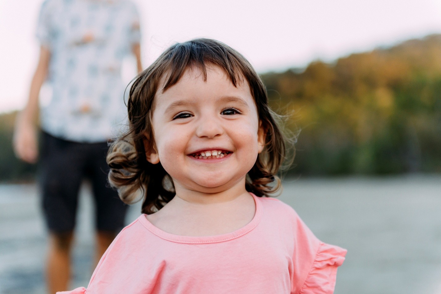 A smiling toddler on a beach