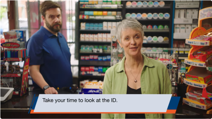 A picture of two people in a retail store. By clicking on the picture, a short retailer training video will play.