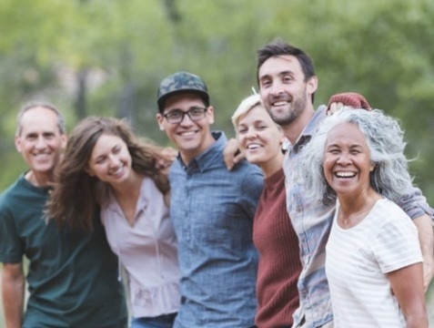 Two women sitting outdoors with beverage mugs