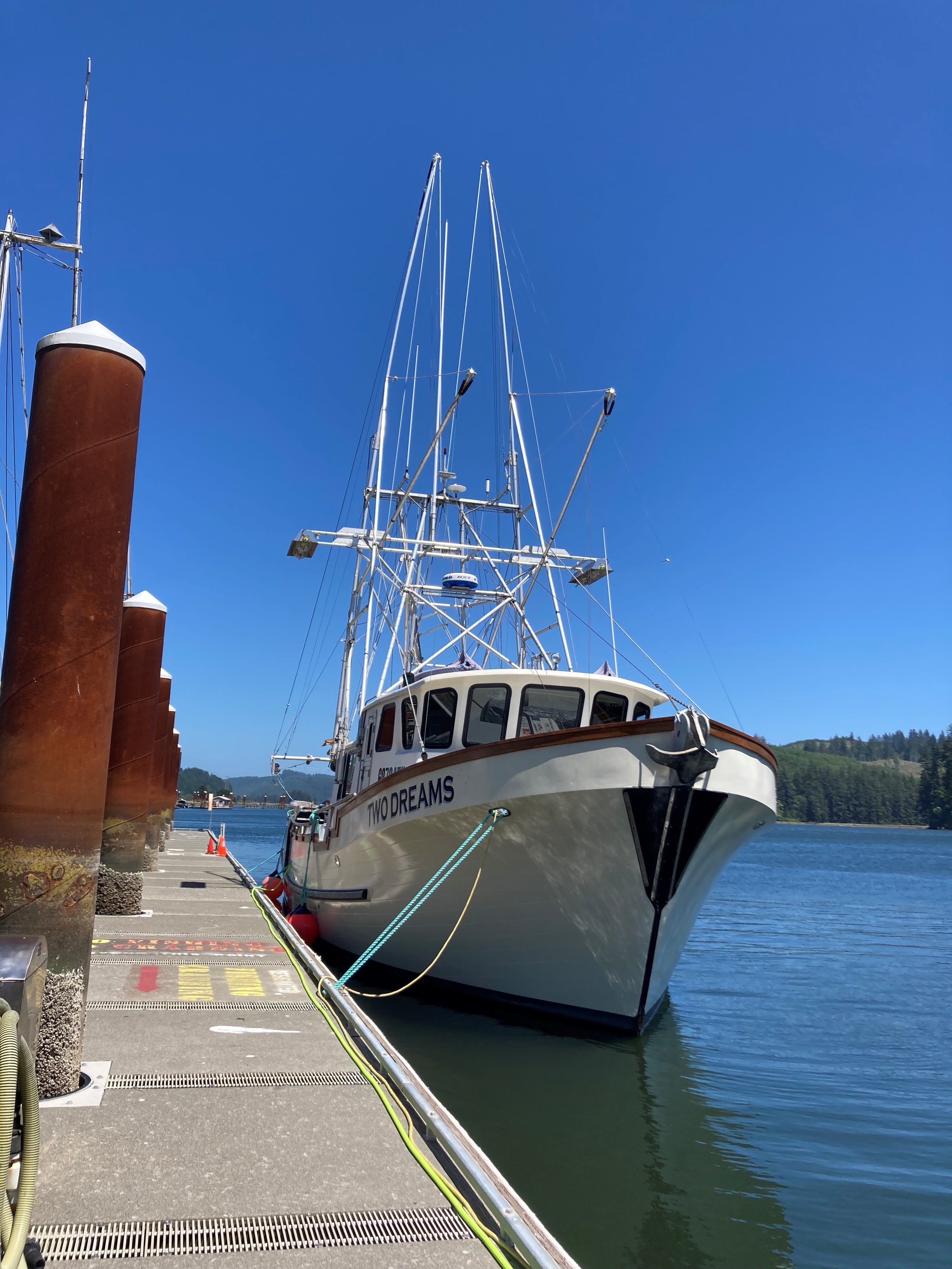 Large enclosed cabin boat tied up on the long dock at the Port of Siuslaw