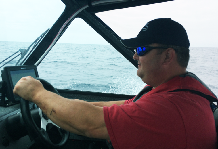 Image of the agency director at the helm of his motorized boat