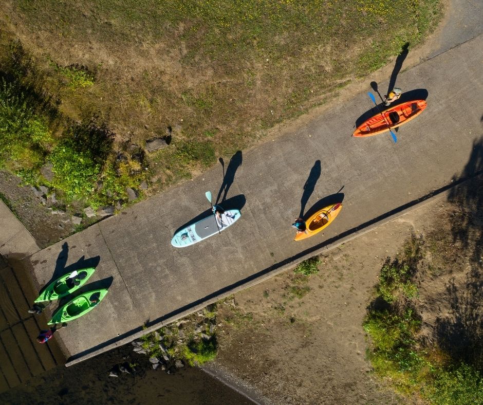 Paddlers ready to launch from a boat ramp