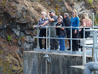 Governor Tina Kotek standing on a concrete platform with members of the Cow Creek Band of Umpqua Tribe of Indians