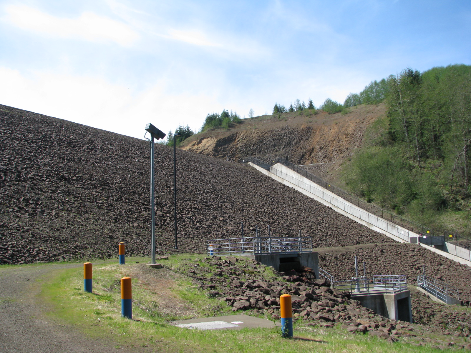 A photo of a dam just outside of McMinnville. The photo shows the embankment, emergency spillway and outlet.