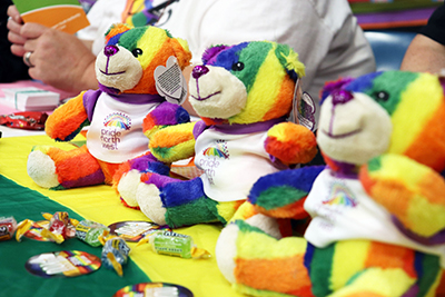 Rainbow colored teddy bears wearing Pride Month shirts