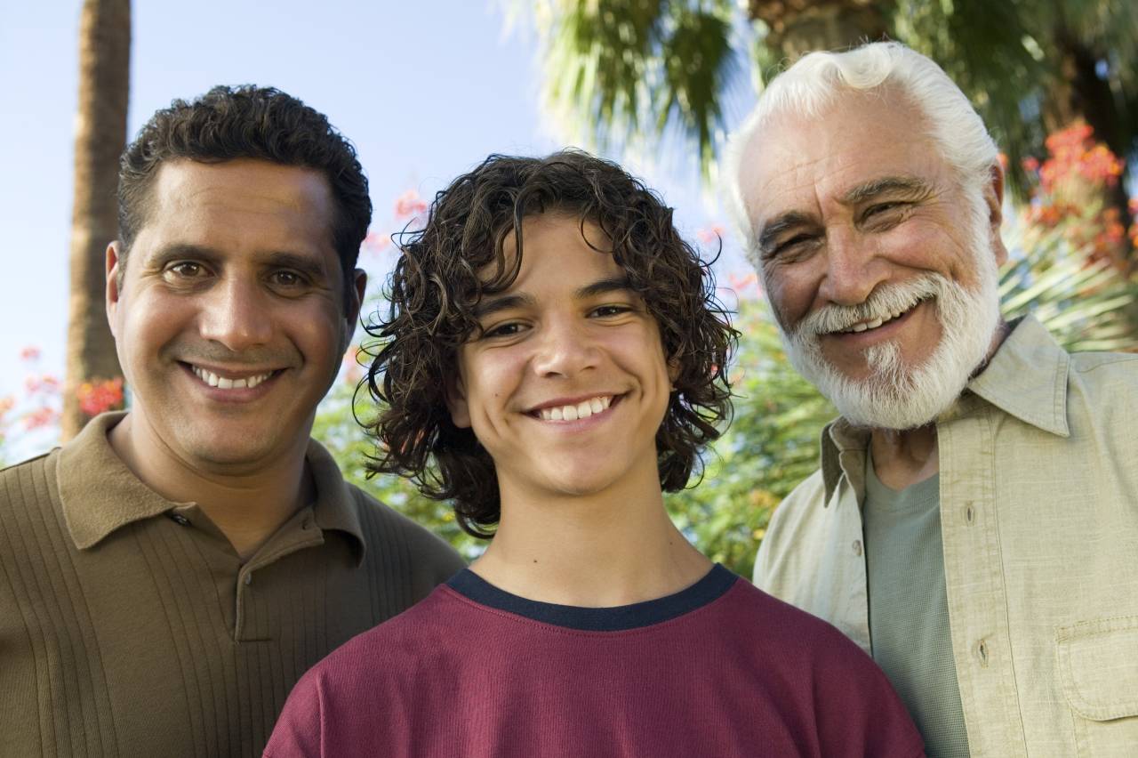Two Latino men standing outside with Latino teenage boy