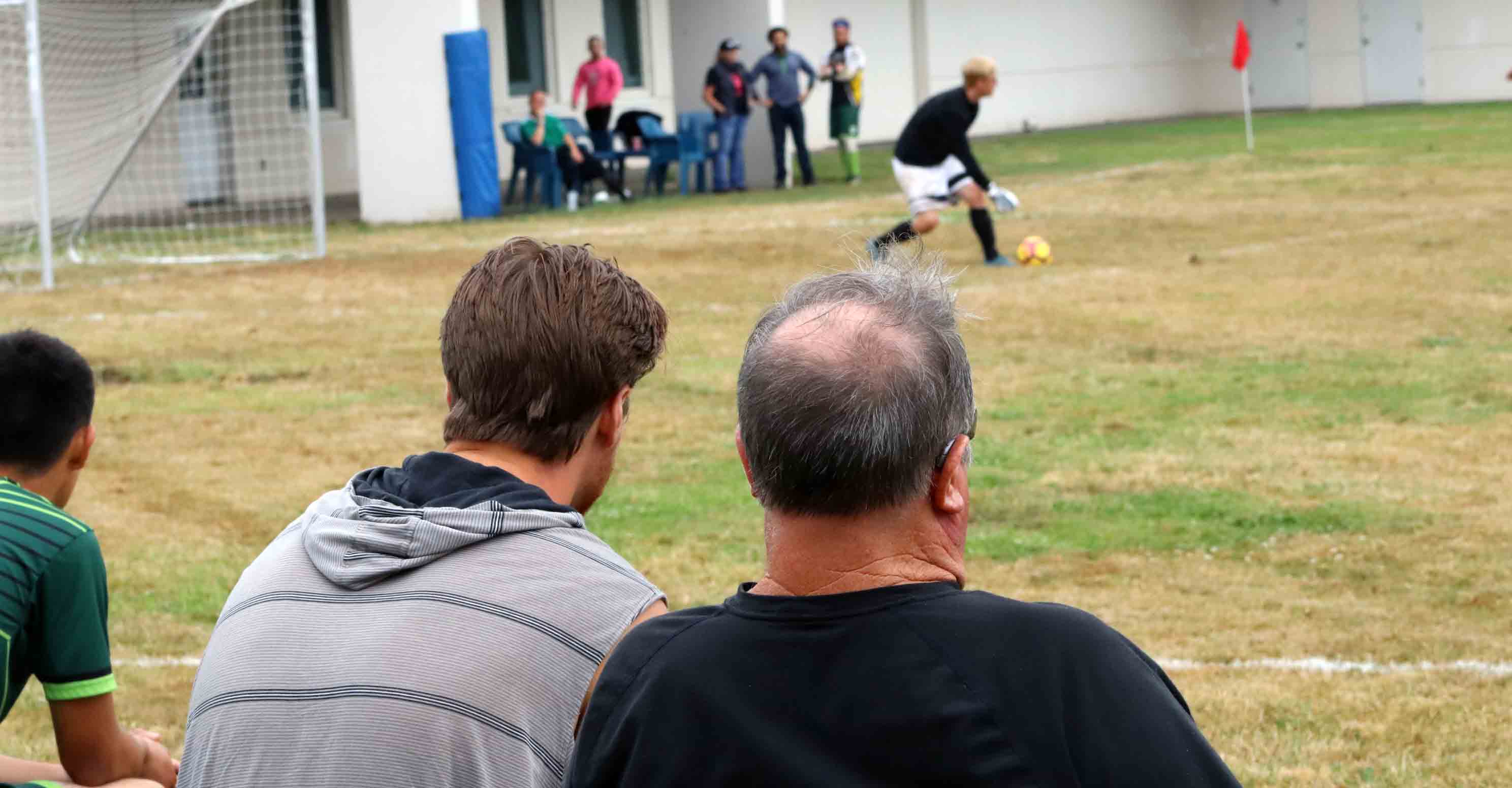 man watching soccer with son