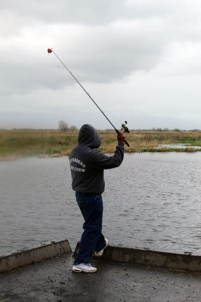 man stands on dock fishing in pond.JPG