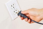 person inserting plug into wall