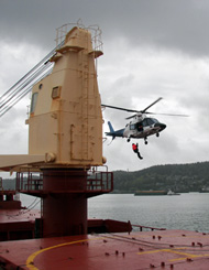 pilot transferring from helicopt to the ship's deck
